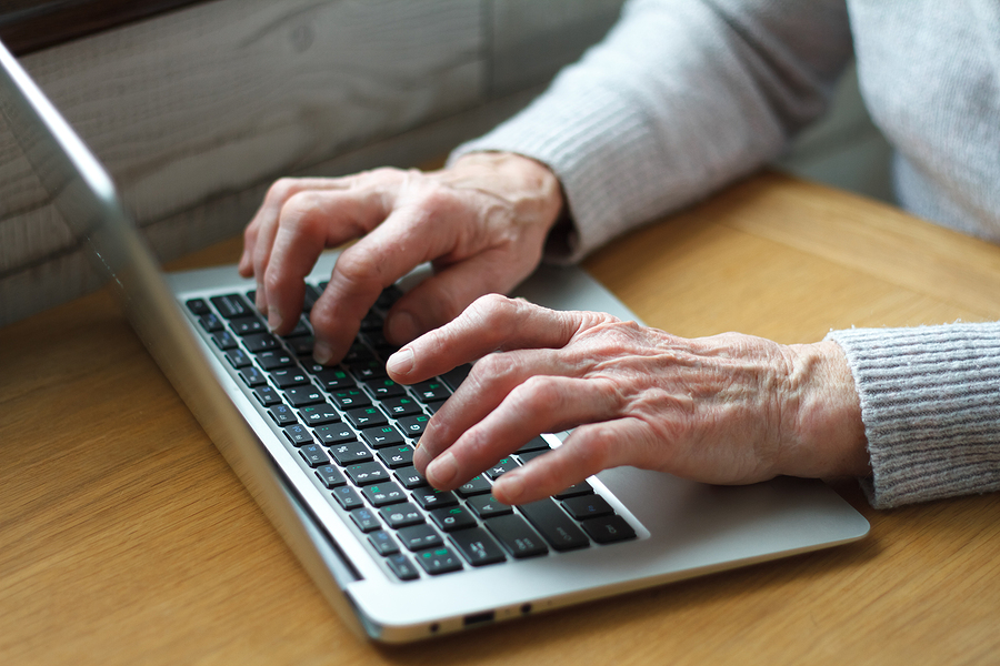 Mature female hands typing text on keyboard, senior elderly business woman working on laptop, old or middle aged lady using computer concept writing emails, communicating online, close up view. online presence