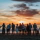 big family standing on shore during golden hour. blended families, stepfamily
